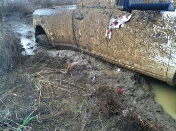 Muddy truck that is stuck in the mud.